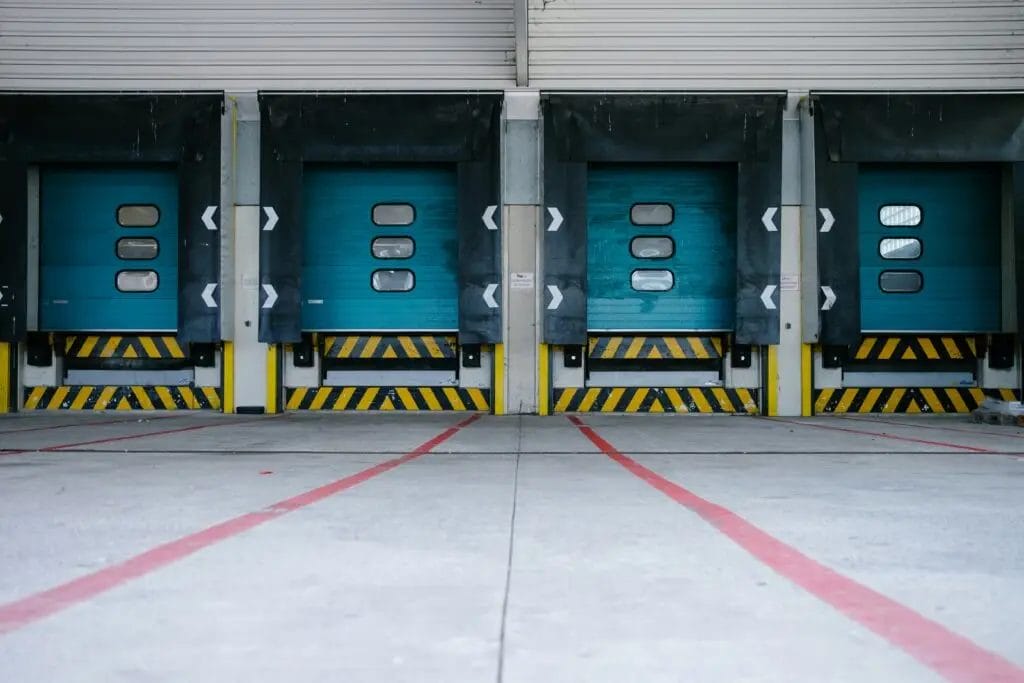 Warehouse loading dock with multiple closed bay doors and safety markings